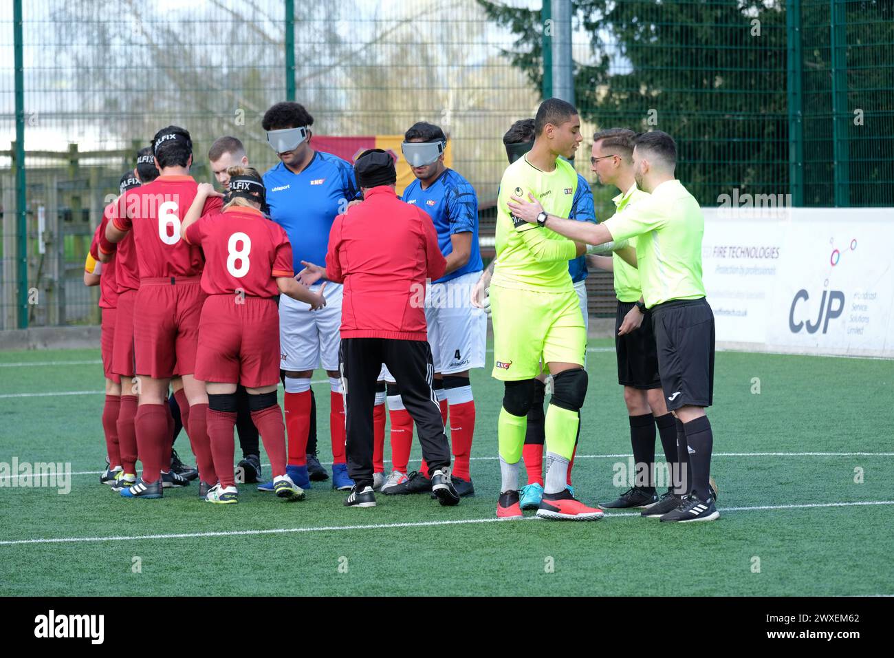 Royal National College for the Blind, Hereford, Regno Unito – sabato 30 marzo 2024 – terza fase della European Blind Football League ( EBFL ) tenutasi presso il Royal National College for the Blind di Hereford, con sei squadre europee. Giocatori del club italiano ASDD Roma 2000 (magliette rosse) stringono la mano a giocatori del club inglese RNC Hereford (magliette blu) prima del calcio d'inizio. Foto Steven May / Alamy Live News Foto Stock