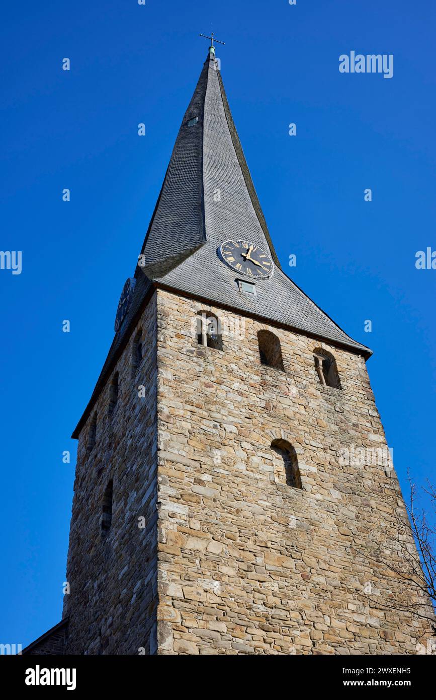 Torre pendente della chiesa di San Giorgio con orologio e facciata in arenaria sotto un cielo azzurro senza nuvole nella città vecchia di Hattingen, Ennepe-Ruhr Foto Stock