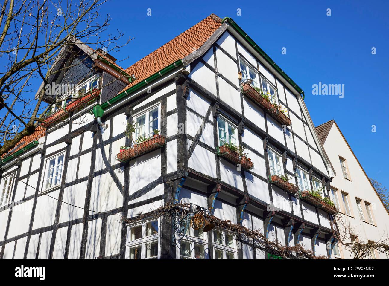 Casa a graticcio con fioriere sotto un cielo azzurro senza nuvole nella città vecchia di Hattingen, nel quartiere Ennepe-Ruhr, a nord Foto Stock