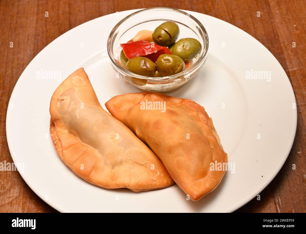 Torta di carne fritta empanada piatto di tapas con ciotola di olive in Spagna Foto Stock