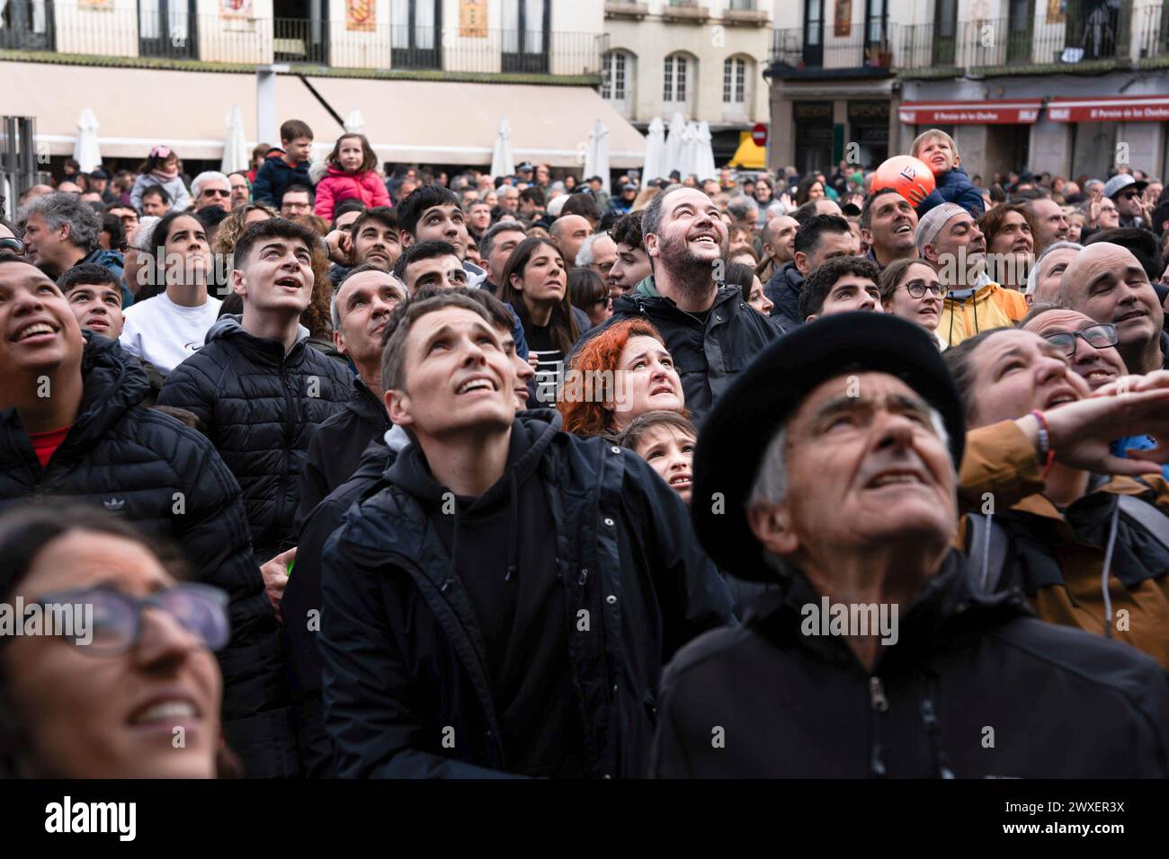 Tudela, Spagna. 30 marzo 2024. Le persone guardano il cielo in attesa della caduta delle mongolfiere Diario de Navarra, circondate da una folla enorme durante la celebrazione del VolatÃŒn. Centinaia di persone si sono riunite nella Plaza de los Fueros a Tudela, Navarra, per illuminare il tradizionale VolatÃ-n, un burattino articolato con elementi pirotecnici all'interno che gira e colpisce un bastone che simboleggia la morte agonizzante di Giuda Iscariota. (Credit Image: © Ximena Borrazas/SOPA Images via ZUMA Press Wire) SOLO PER USO EDITORIALE! Non per USO commerciale! Crediti: ZUMA Press, Inc./Alamy Live News Foto Stock