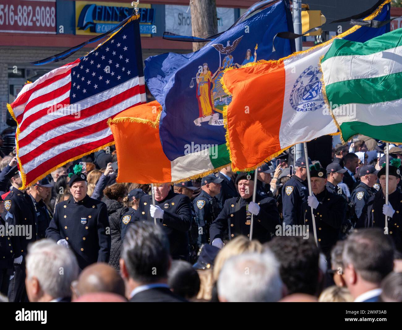 New York, Stati Uniti. 30 marzo 2024. La Guardia del colore cammina di fronte al focolare guidando la processione. Il funerale per l'agente caduto della polizia di New York Jonathan Diller si è tenuto con centinaia di agenti di polizia allineati davanti alla St Rosa di Lima Chiesa cattolica Toman. Secondo i rapporti della polizia, l'agente Diller, di 31 anni, e il suo partner stavano facendo una fermata per un'auto parcheggiata illegalmente a far Rockaway. Durante l'incontro, un individuo nel veicolo brandiva un'arma da fuoco e la puntava agli ufficiali, provocando uno scambio di colpi di arma da fuoco. Credito: SOPA Images Limited/Alamy Live News Foto Stock