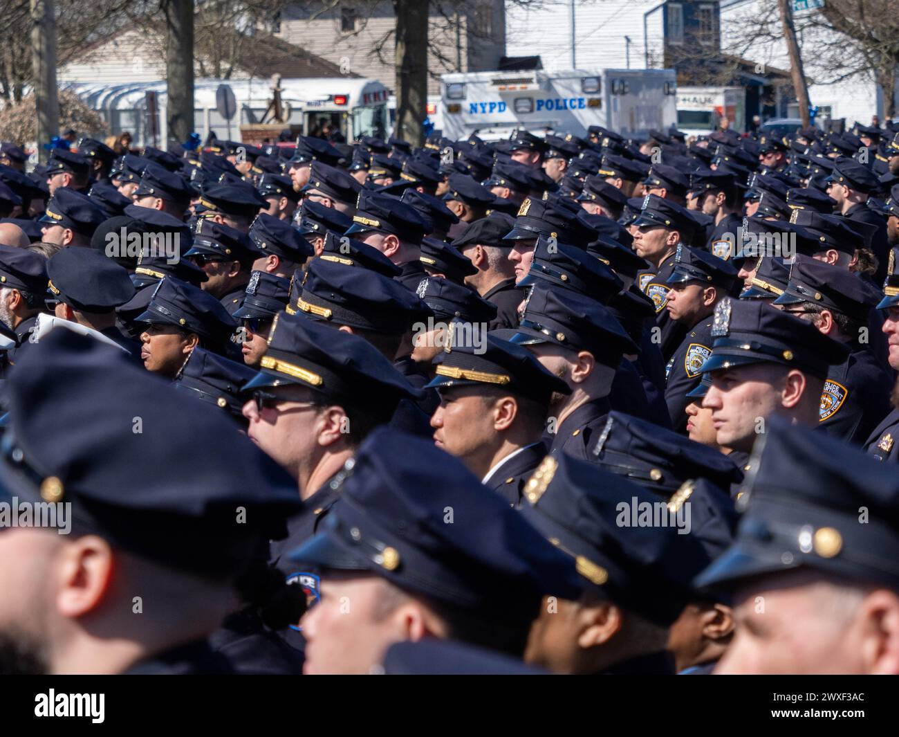 New York, Stati Uniti. 30 marzo 2024. Gli agenti di polizia stanno in guardia prima dell'inizio della processione. Il funerale per l'agente caduto della polizia di New York Jonathan Diller si è tenuto con centinaia di agenti di polizia allineati davanti alla St Rosa di Lima Chiesa cattolica Toman. Secondo i rapporti della polizia, l'agente Diller, di 31 anni, e il suo partner stavano facendo una fermata per un'auto parcheggiata illegalmente a far Rockaway. Durante l'incontro, un individuo nel veicolo brandiva un'arma da fuoco e la puntava agli ufficiali, provocando uno scambio di colpi di arma da fuoco. Credito: SOPA Images Limited/Alamy Live News Foto Stock