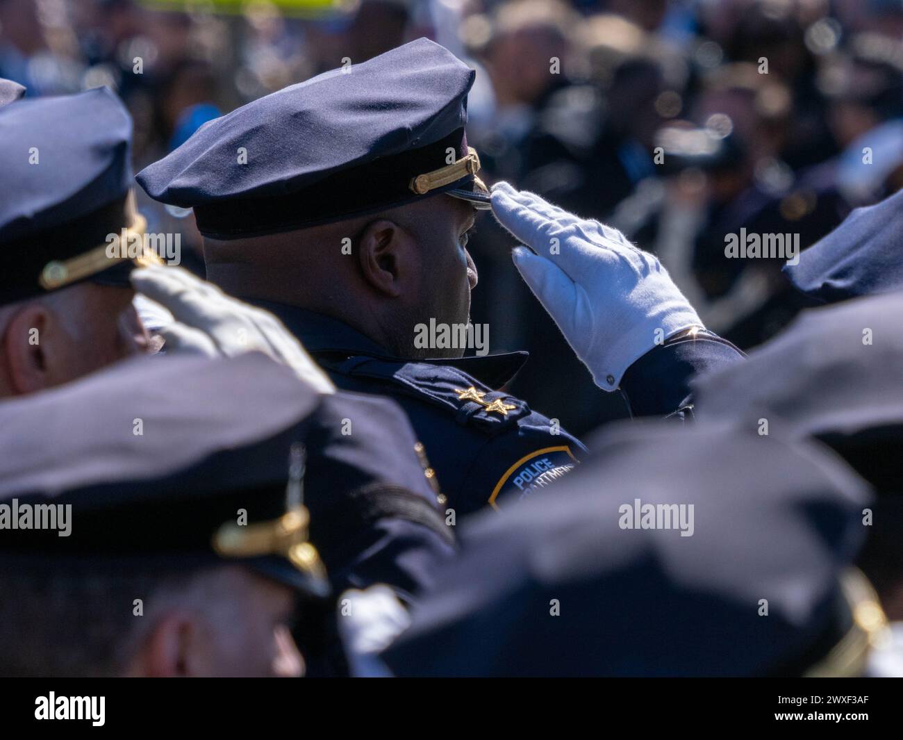 New York, Stati Uniti. 30 marzo 2024. Gli agenti di polizia stanno in piedi mentre salutano la bara. Il funerale per l'agente caduto della polizia di New York Jonathan Diller si è tenuto con centinaia di agenti di polizia allineati davanti alla St Rosa di Lima Chiesa cattolica Toman. Secondo i rapporti della polizia, l'agente Diller, di 31 anni, e il suo partner stavano facendo una fermata per un'auto parcheggiata illegalmente a far Rockaway. Durante l'incontro, un individuo nel veicolo brandiva un'arma da fuoco e la puntava agli ufficiali, provocando uno scambio di colpi di arma da fuoco. Credito: SOPA Images Limited/Alamy Live News Foto Stock