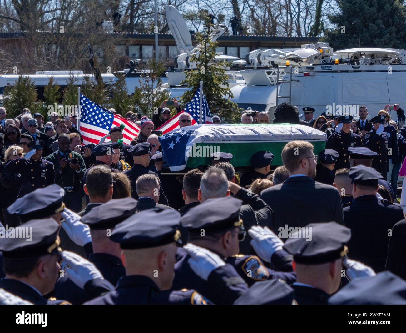 New York, Stati Uniti. 30 marzo 2024. Gli agenti di polizia stanno in piedi mentre salutano la bara. Il funerale per l'agente caduto della polizia di New York Jonathan Diller si è tenuto con centinaia di agenti di polizia allineati davanti alla St Rosa di Lima Chiesa cattolica Toman. Secondo i rapporti della polizia, l'agente Diller, di 31 anni, e il suo partner stavano facendo una fermata per un'auto parcheggiata illegalmente a far Rockaway. Durante l'incontro, un individuo nel veicolo brandiva un'arma da fuoco e la puntava agli ufficiali, provocando uno scambio di colpi di arma da fuoco. Credito: SOPA Images Limited/Alamy Live News Foto Stock