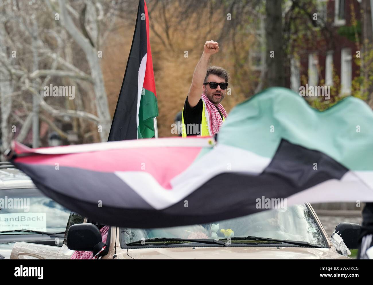 St Louis, Stati Uniti. 30 marzo 2024. Un sostenitore palestinese pro siede in cima a un'auto durante una lunga sfilata per le strade di St Louis il sabato 30 marzo 2024. La manifestazione ha fermato il traffico mentre i canti della "Palestina libera” sono stati urlati dalle auto. Foto di Bill Greenblatt/UPI credito: UPI/Alamy Live News Foto Stock