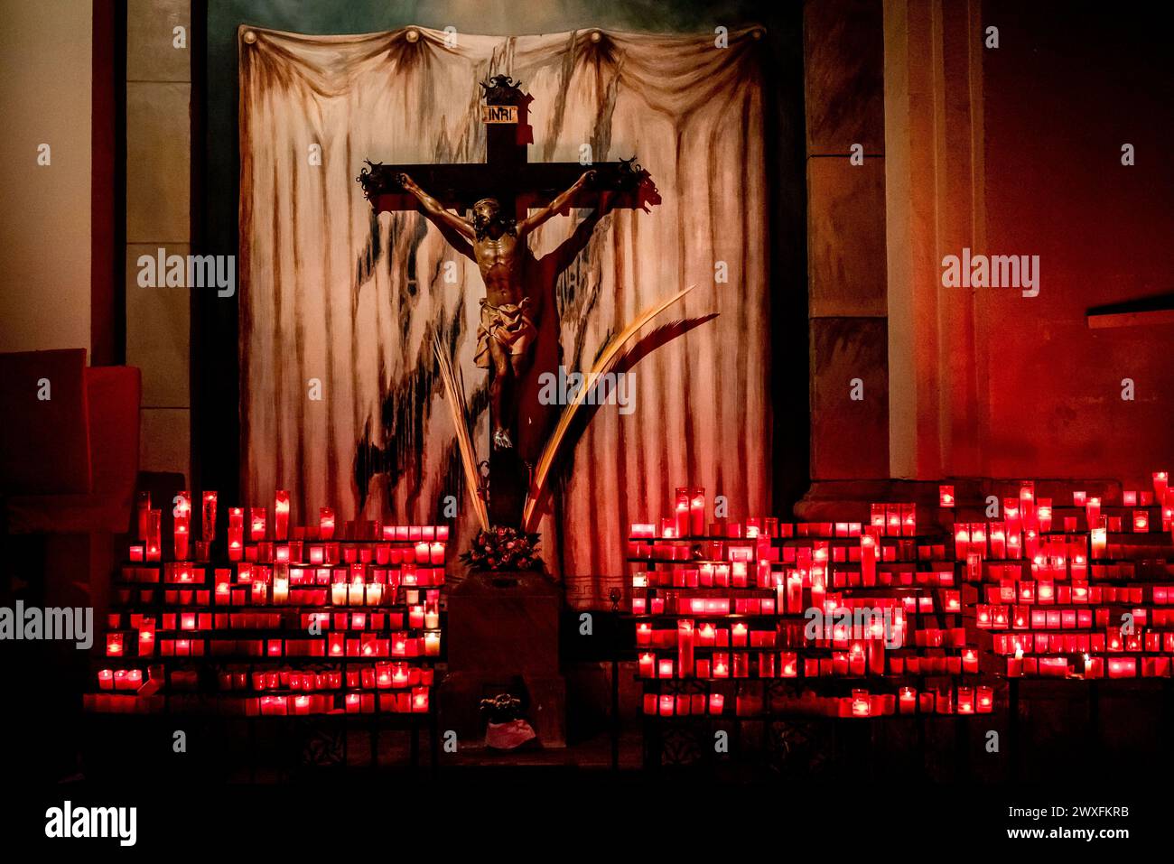 Barcellona, Spagna. 30 marzo 2024, Barcellona, Spagna: La statua di Gesù Cristo circondata da candele accese da fedeli e credenti nella Chiesa di Sant Agusti a Barcellona durante il sabato Santo. Crediti: Jordi Boixareu/Alamy Live News Foto Stock