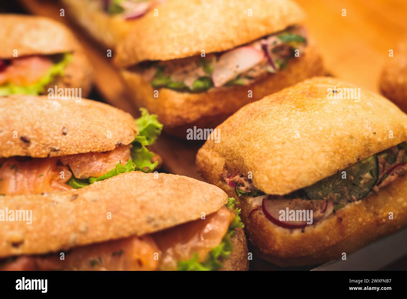 Tavolo da banchetto con catering splendidamente decorato con diversi spuntini e antipasti con sandwich, bagel, baguette club sottomarino sandwi Foto Stock