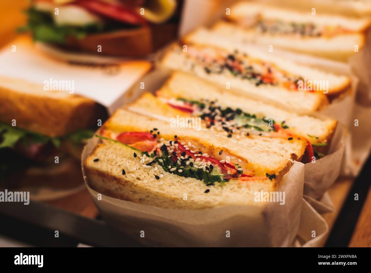 Tavolo da banchetto con catering splendidamente decorato con diversi spuntini e antipasti con sandwich, bagel, baguette club sottomarino sandwi Foto Stock