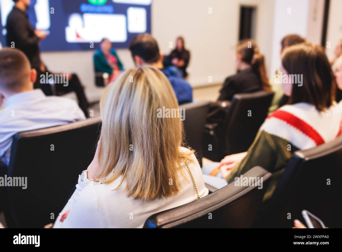 Partecipanti femminili udienza alla riunione del simposio, partecipanti nella sala conferenze ascoltano il docente, gruppo di donne in un congresso insieme li Foto Stock
