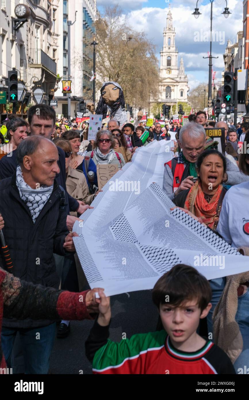 Londra, Regno Unito, 30 marzo 2024. Le persone hanno una lista dei nomi e delle età dei bambini che sono stati uccisi a Gaza dal 7 ottobre. L'undicesima marcia Nazionale per la Palestina comemmorò la giornata della Terra. La manifestazione iniziò a Russell Square, terminando a Trafalgar Square, e fu frequentata da oltre 100.000 persone che chiedevano un cessate il fuoco permanente per la guerra israelo-Hamas. Credito: Fotografia dell'undicesima ora/Alamy Live News Foto Stock