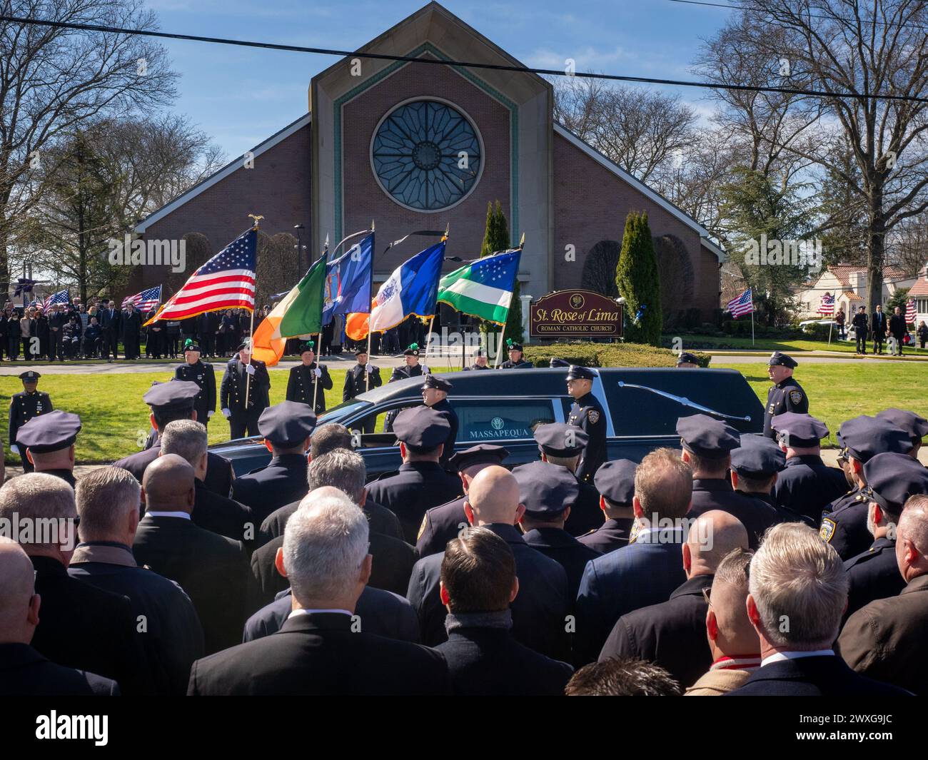 New York, Stati Uniti. 30 marzo 2024. Guida di fronte al St Chiesa Rosa di Lima. Il funerale per l'agente caduto della polizia di New York Jonathan Diller si è tenuto con centinaia di agenti di polizia allineati davanti alla St Rosa di Lima Chiesa cattolica Toman. Secondo i rapporti della polizia, l'agente Diller, di 31 anni, e il suo partner stavano facendo una fermata per un'auto parcheggiata illegalmente a far Rockaway. Durante l'incontro, un individuo nel veicolo brandiva un'arma da fuoco e la puntava agli ufficiali, provocando uno scambio di colpi di arma da fuoco. Credito: SOPA Images Limited/Alamy Live News Foto Stock