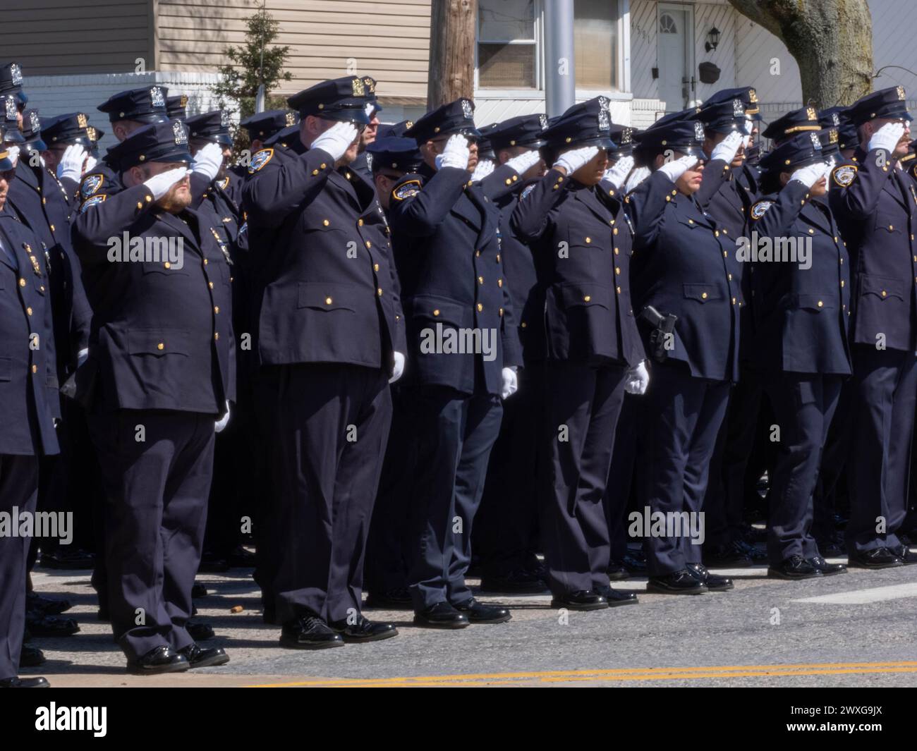 New York, Stati Uniti. 30 marzo 2024. Gli agenti della polizia di New York salutano mentre passa il focolare. Il funerale per l'agente caduto della polizia di New York Jonathan Diller si è tenuto con centinaia di agenti di polizia allineati davanti alla St Rosa di Lima Chiesa cattolica Toman. Secondo i rapporti della polizia, l'agente Diller, di 31 anni, e il suo partner stavano facendo una fermata per un'auto parcheggiata illegalmente a far Rockaway. Durante l'incontro, un individuo nel veicolo brandiva un'arma da fuoco e la puntava agli ufficiali, provocando uno scambio di colpi di arma da fuoco. Credito: SOPA Images Limited/Alamy Live News Foto Stock