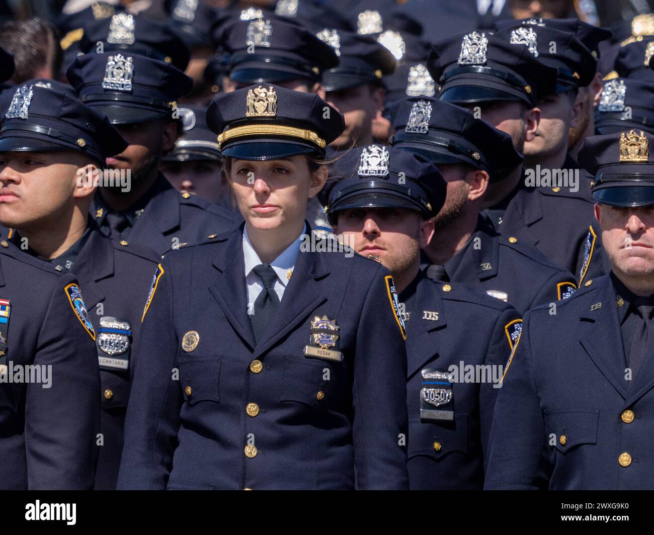 New York, Stati Uniti. 30 marzo 2024. Gli agenti della polizia di New York sono in guardia alla fine della processione funebre per il caduto agente della polizia di New York Jonathan Diller è stato tenuto con centinaia di agenti di polizia schierati davanti alla St Rosa di Lima Chiesa cattolica Toman. Secondo i rapporti della polizia, l'agente Diller, di 31 anni, e il suo partner stavano facendo una fermata per un'auto parcheggiata illegalmente a far Rockaway. Durante l'incontro, un individuo nel veicolo brandiva un'arma da fuoco e la puntava agli ufficiali, provocando uno scambio di colpi di arma da fuoco. Credito: SOPA Images Limited/Alamy Live News Foto Stock