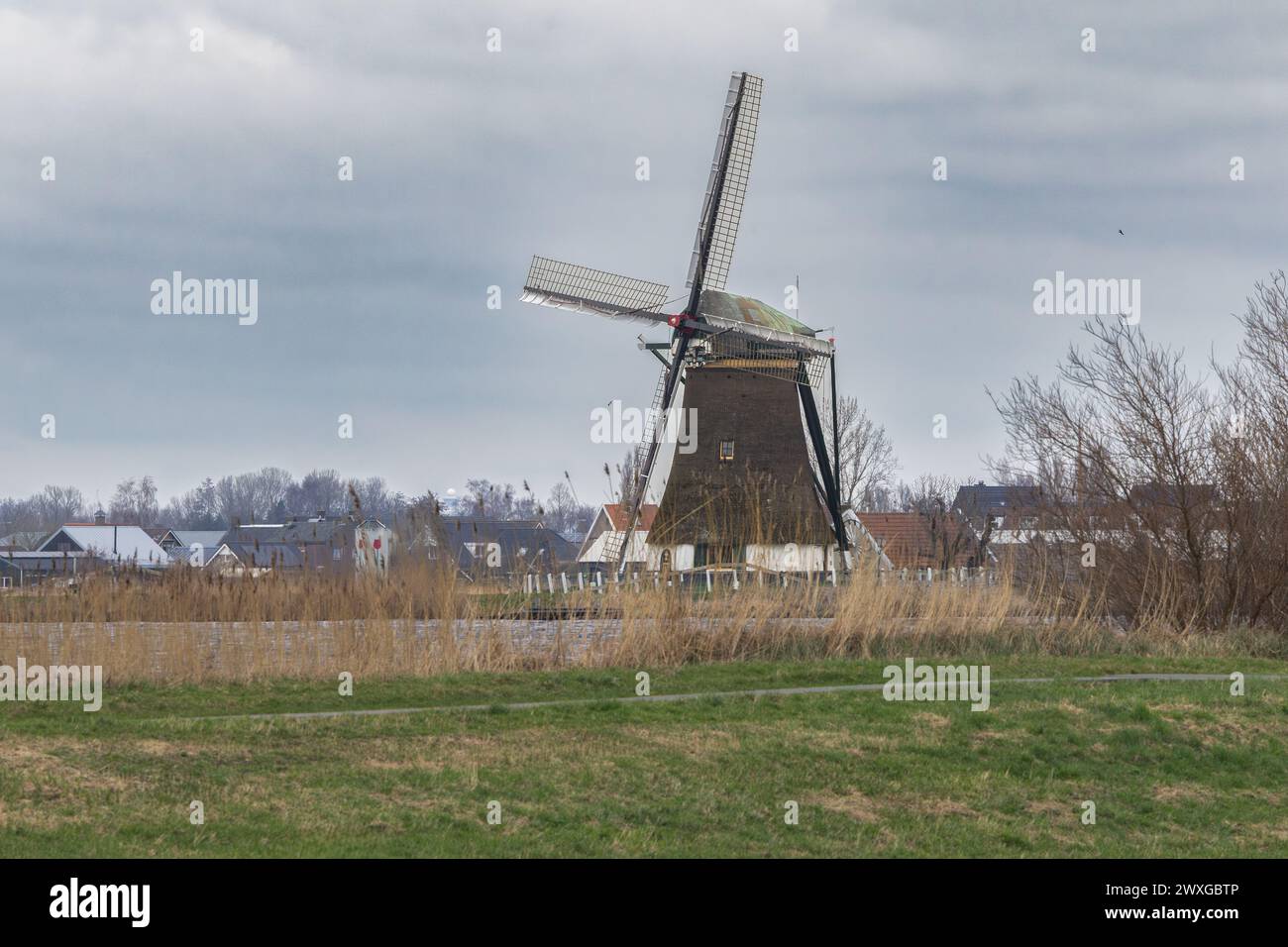 Vista dello storico Veendermolen con il cottage di miller sul seno della Weide AA vicino al villaggio olandese di Roelofarendsveen contro la B. Foto Stock