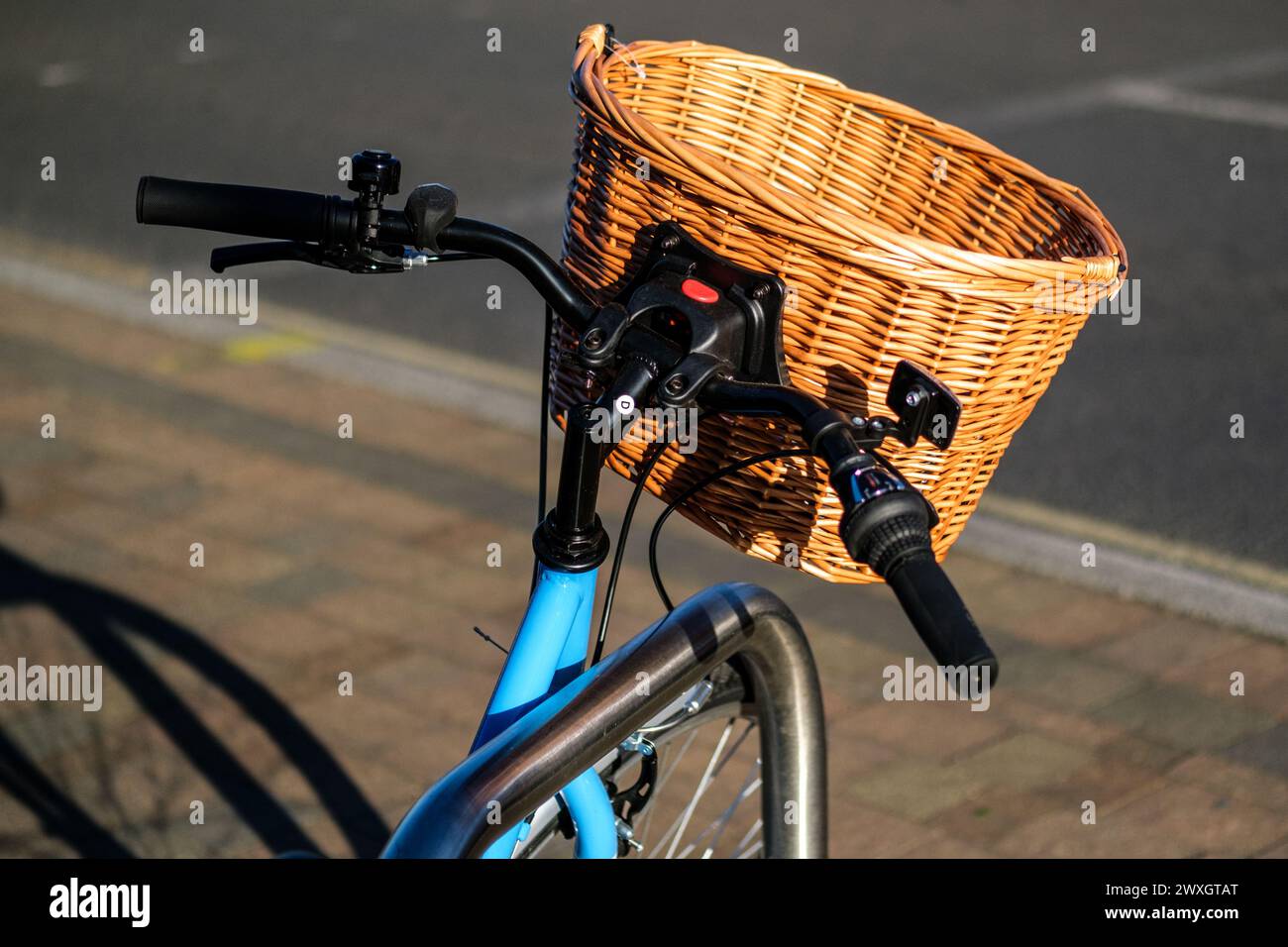 Epsom Surrey, Regno Unito, marzo 30 2024, Staitionenry Blue Bicycle with A Wicker Shopping Basket attaccato al manubrio senza persone Foto Stock