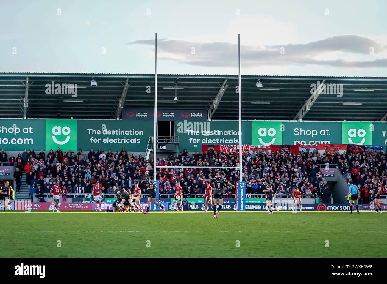 Salford, Manchester, Regno Unito. 30 marzo 2024. Super League Rugby: Salford Red Devils vs Leigh Leopards al Salford Community Stadium. Tifosi di Salford dietro la postazione durante la partita. Credito James Giblin/Alamy Live News. Foto Stock