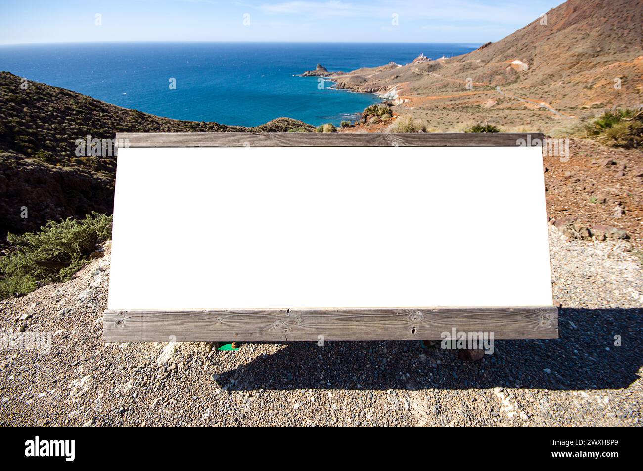 Una lavagna bianca con un oggetto all'interno, posta su ghiaia Foto Stock