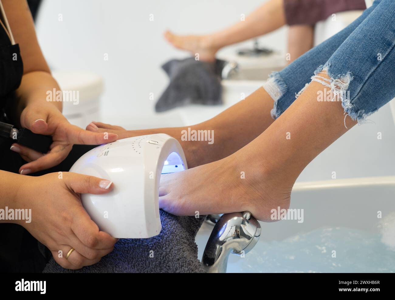 Donna che fa la pedicure con un asciugapunte professionale Foto Stock