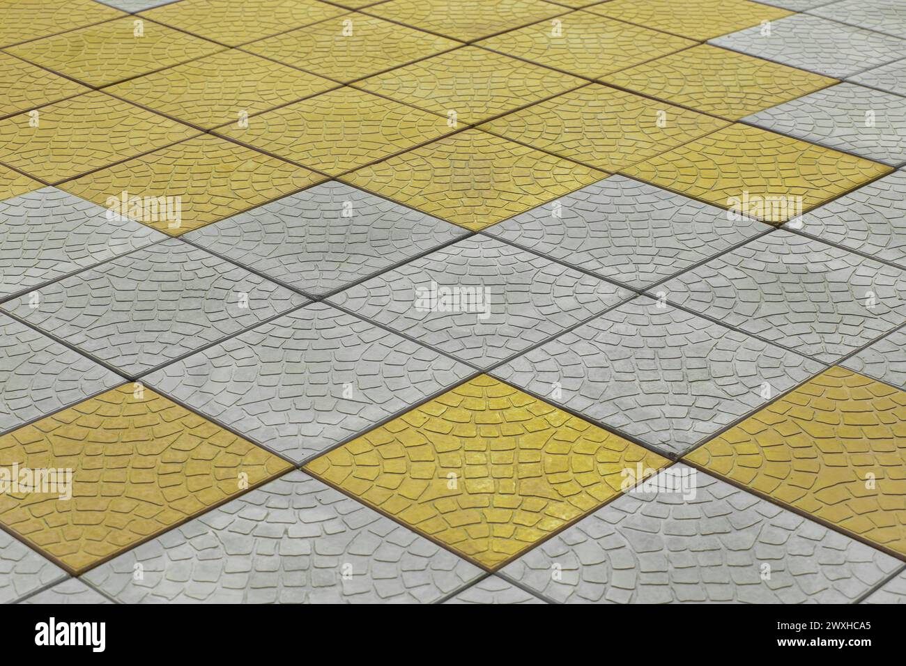Lastre di pavimentazione gialle grigie con motivo diagonale superficie stradale superficie stradale fondo stradale texture città pavimentazione urbana. Foto Stock