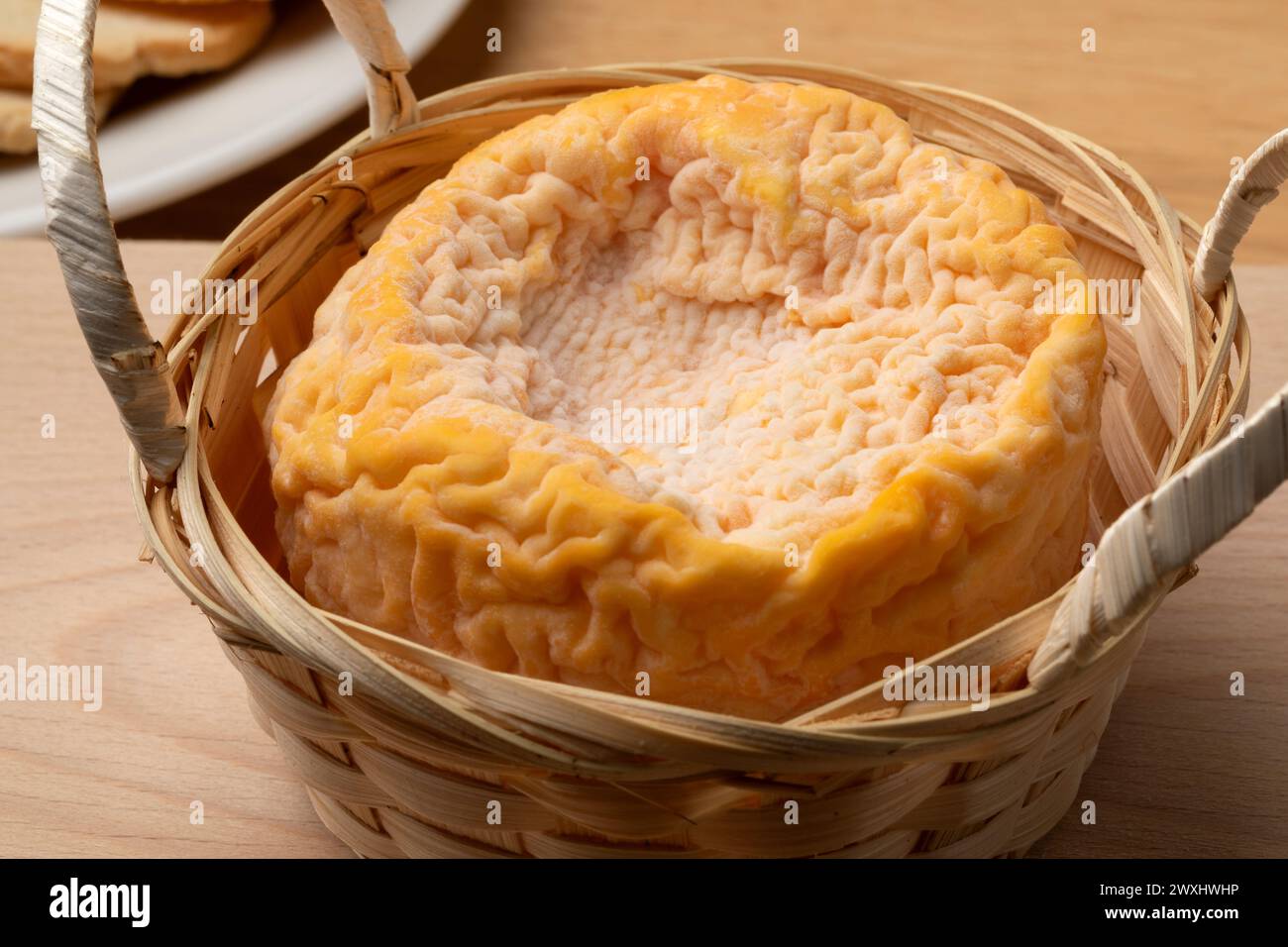 Formaggio francese Langres raffinato con champagne in un cesto da primo piano Foto Stock