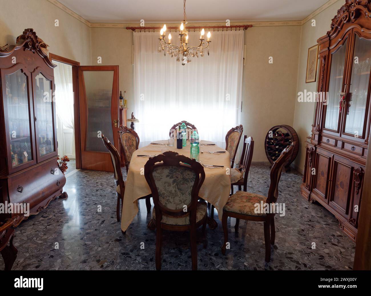 Elegante sala da pranzo con tradizionali armadi in legno, tavolo e sedie in un appartamento a Montefiascone, Lazio, Italia. 31 marzo 2024 Foto Stock
