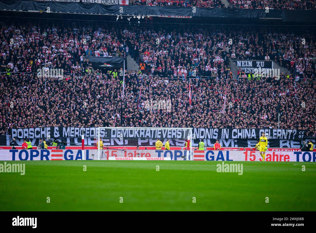 31 marzo 2024, Baden-Württemberg, Stoccarda: Calcio: Bundesliga, VfB Stoccarda - 1. FC Heidenheim, Matchday 27, MHPArena. I tifosi del VfB Stuttgart protestano negli stand durante i primi dieci minuti della partita con striscioni che recano "Porsche & Mercedes: Imparato a capire la democrazia in Cina?" e rifiutarsi di dare il loro sostegno. Foto: Tom Weller/dpa - NOTA IMPORTANTE: In conformità con le normative della DFL German Football League e della DFB German Football Association, è vietato utilizzare o far utilizzare fotografie scattate nello stadio e/o della partita sotto forma di im sequenziale Foto Stock