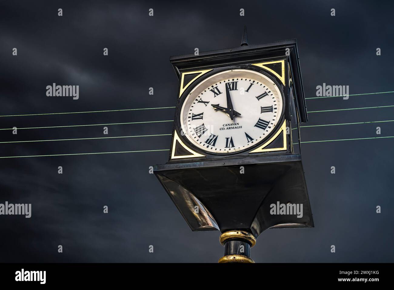 Finglas Village, Dublino: Primo piano dello storico orologio Canavan contro il cielo scuro. Foto Stock