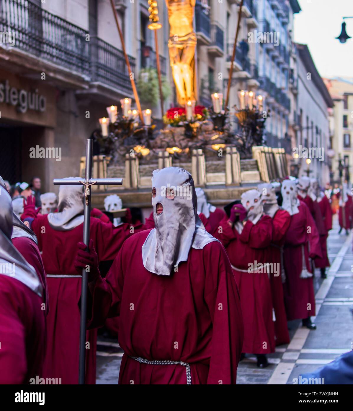 Processione di persone in abiti rossi e maschere bianche Foto Stock