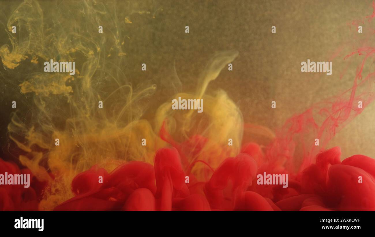 Miscela di fumo. Flusso dell'acqua dell'inchiostro. Nube di vapore rosso giallo effetto acrilico fluido texture su particelle di colore oro sfocate sfondo artistico astratto. Foto Stock
