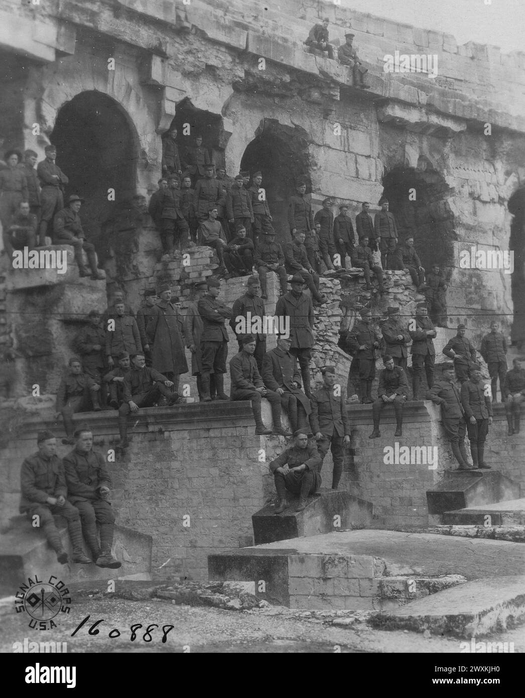 I soldati stanno sulle rovine di un'arena, costruita dai romani tra gli anni 138 e 150 d.C., per guardare i soldati giocare una partita di baseball; Nimes, Gard, France ca. 1919 Foto Stock