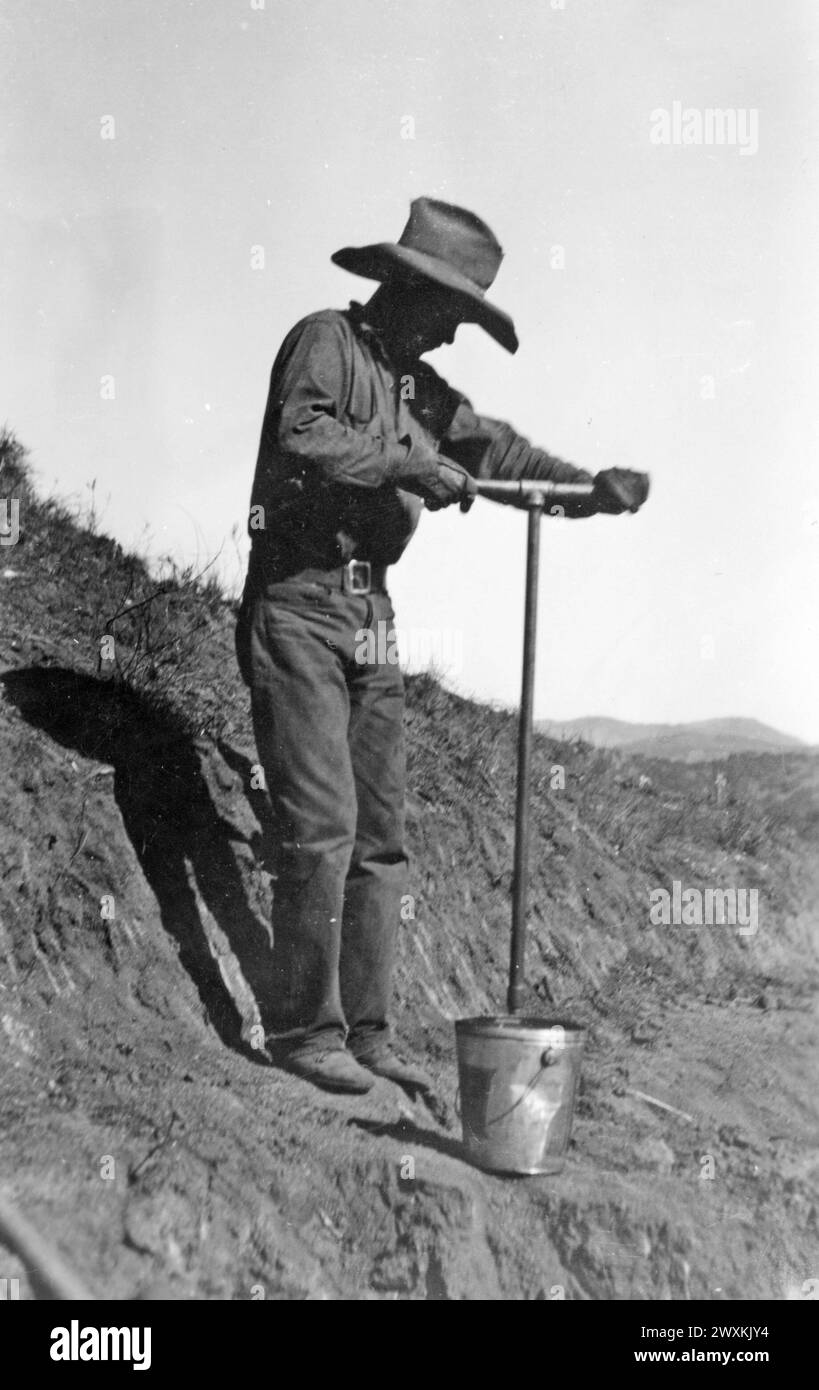 Mesa grande Band of Diegueno Mission Indians, California: Photograph of Worker Drilling with Auger in Soft Decomposed Granite on Truck Trail at Mesa grande CA. 1936-1942 Foto Stock