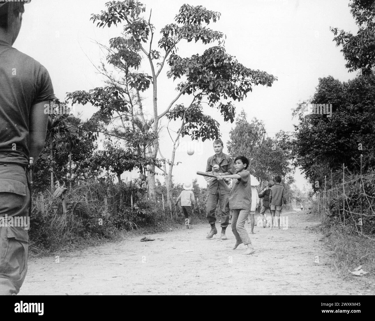 Guerra del Vietnam: I membri del 3rd Battalion, 187th Infantry, 101st Airborne Division (Airmobile), si uniscono ai figli del villaggio AP Uu Thoung in una partita di baseball CA. 1970 Foto Stock