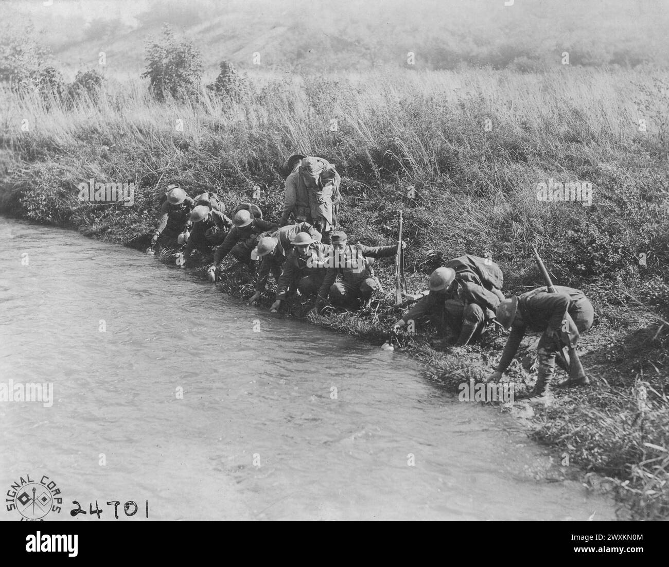 Soldati della compagnia 'i' 109th Regiment, fanteria, riempimento mense in un ruscello vicino Boureuilles, Francia ca. 1918 Foto Stock