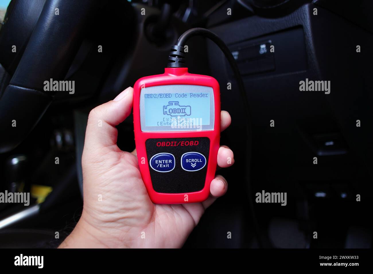 Scanner OBD2 o OBD in una mano meccanica automatica per l'analisi del sistema motore, concetto di manutenzione dell'auto Foto Stock