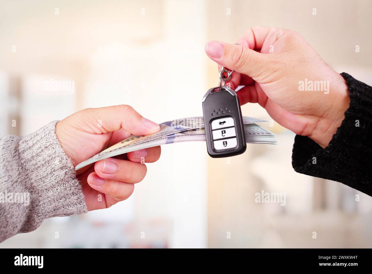 Concetto di negoziazione o prestito auto , banconote e chiavi auto in mano per il cambio Foto Stock