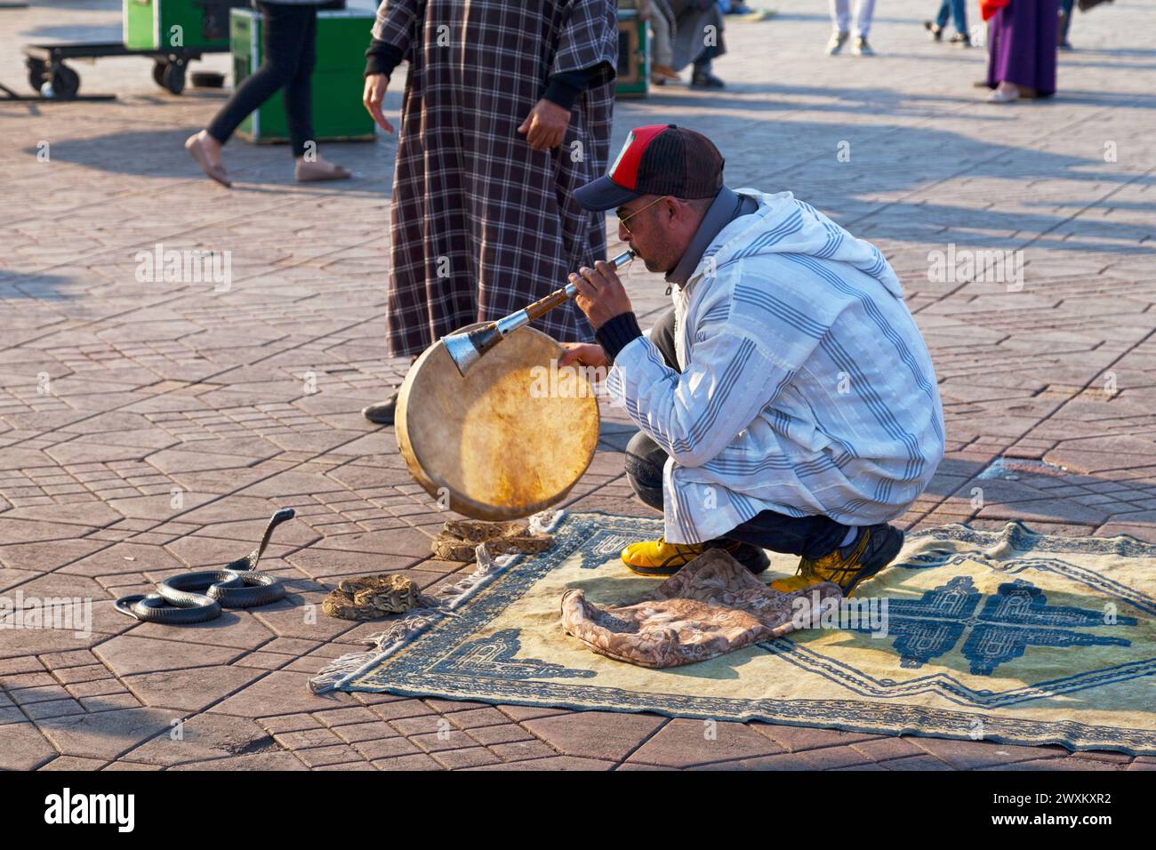 Marrakech, Marocco - gennaio 28 2019: Un incantatore di serpenti che ipnotizza un cobra in Piazza Djemaa El Fna. Foto Stock