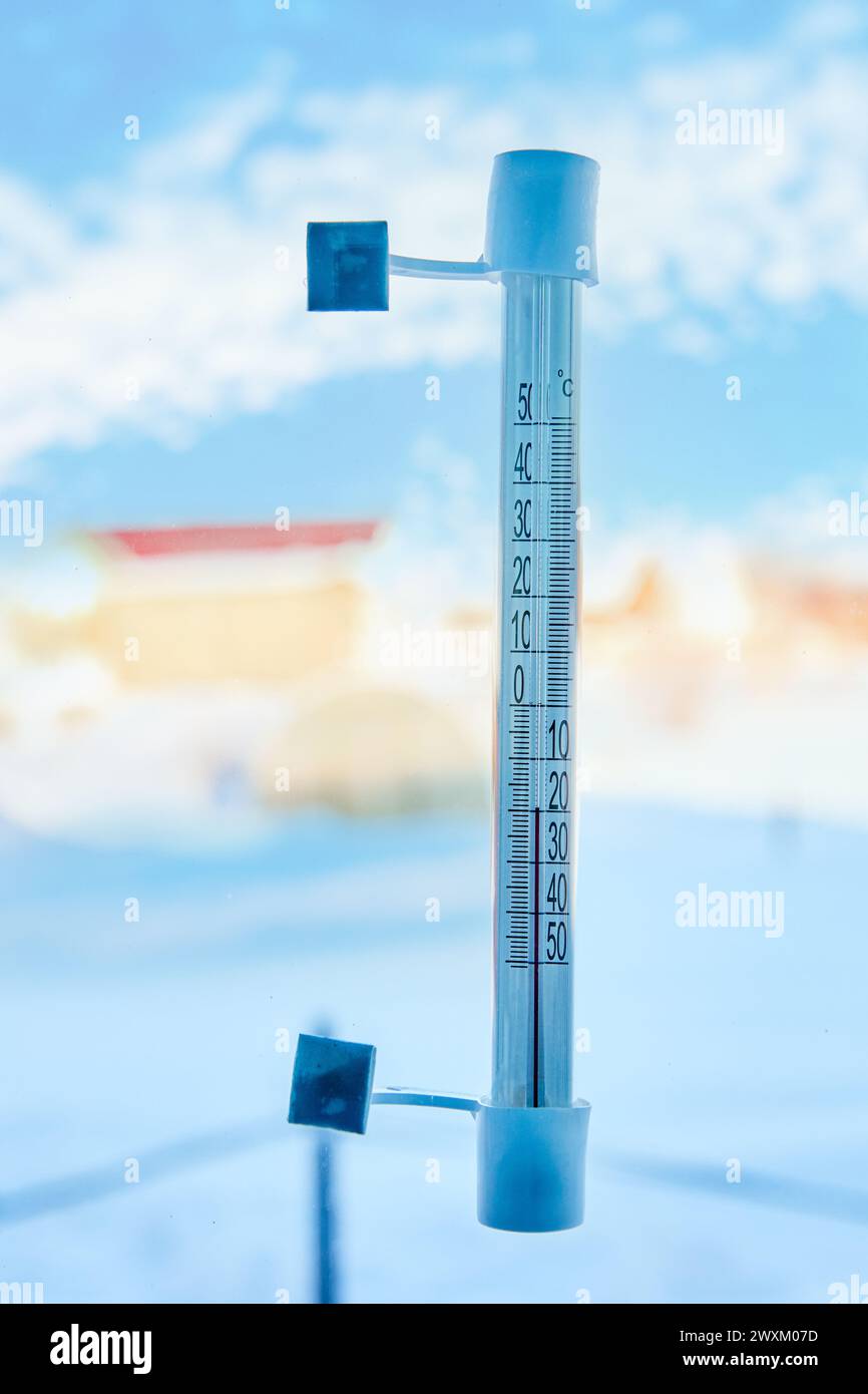 Un termometro per esterni è fissato con nastro adesivo al vetro della finestra all'esterno, su una scala di 20 gradi sotto zero Celsius. Foto Stock