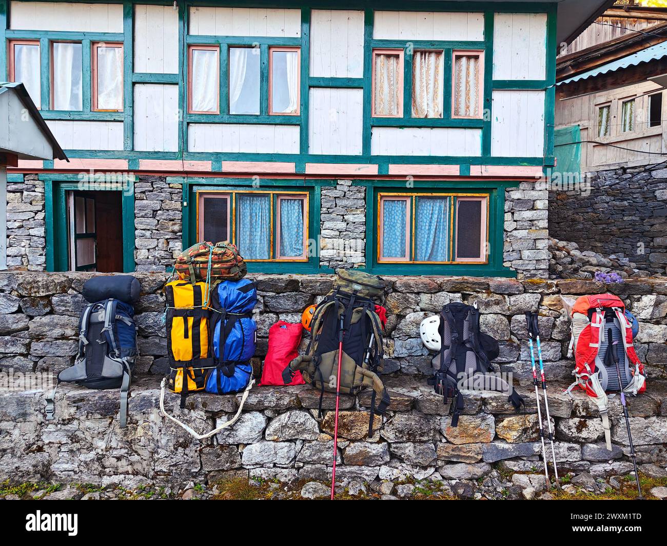 Zaini e bastoncini da trekking contro un Lodge dell'Himalaya, Nepal. Foto Stock
