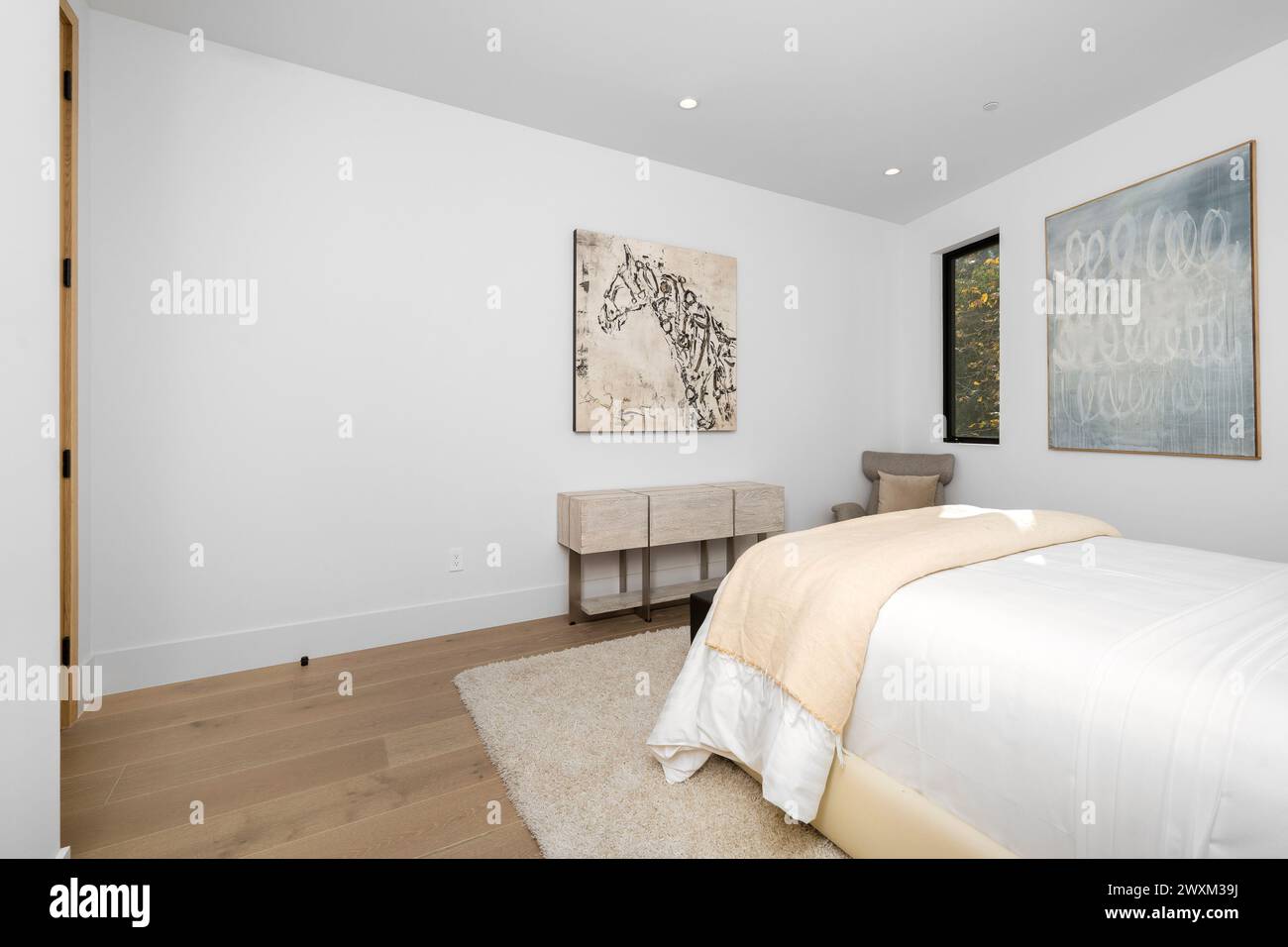 Una camera da letto e una scrivania accanto ad una finestra con le opere d'arte. Foto Stock
