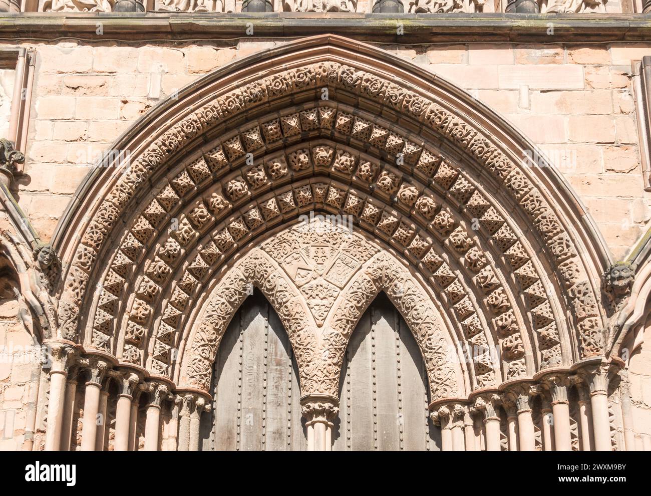 Arco decorato sopra la porta sud della cattedrale di Lichfield, nello Staffordshire, Inghilterra, Regno Unito Foto Stock