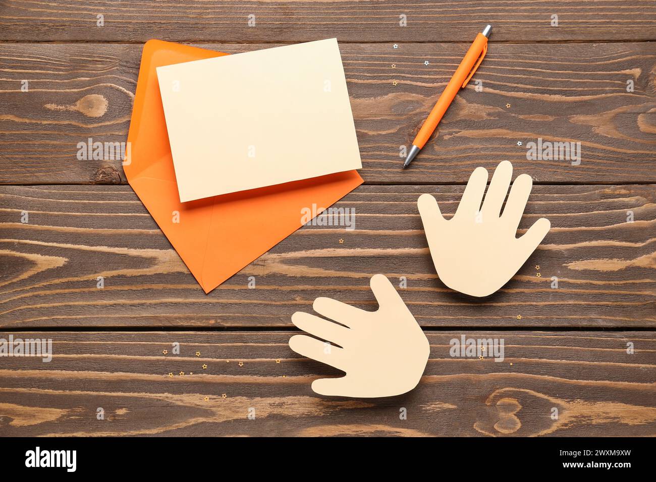 Busta con bigliettino vuoto e palme di carta su sfondo di legno. Festa dell'amicizia Foto Stock