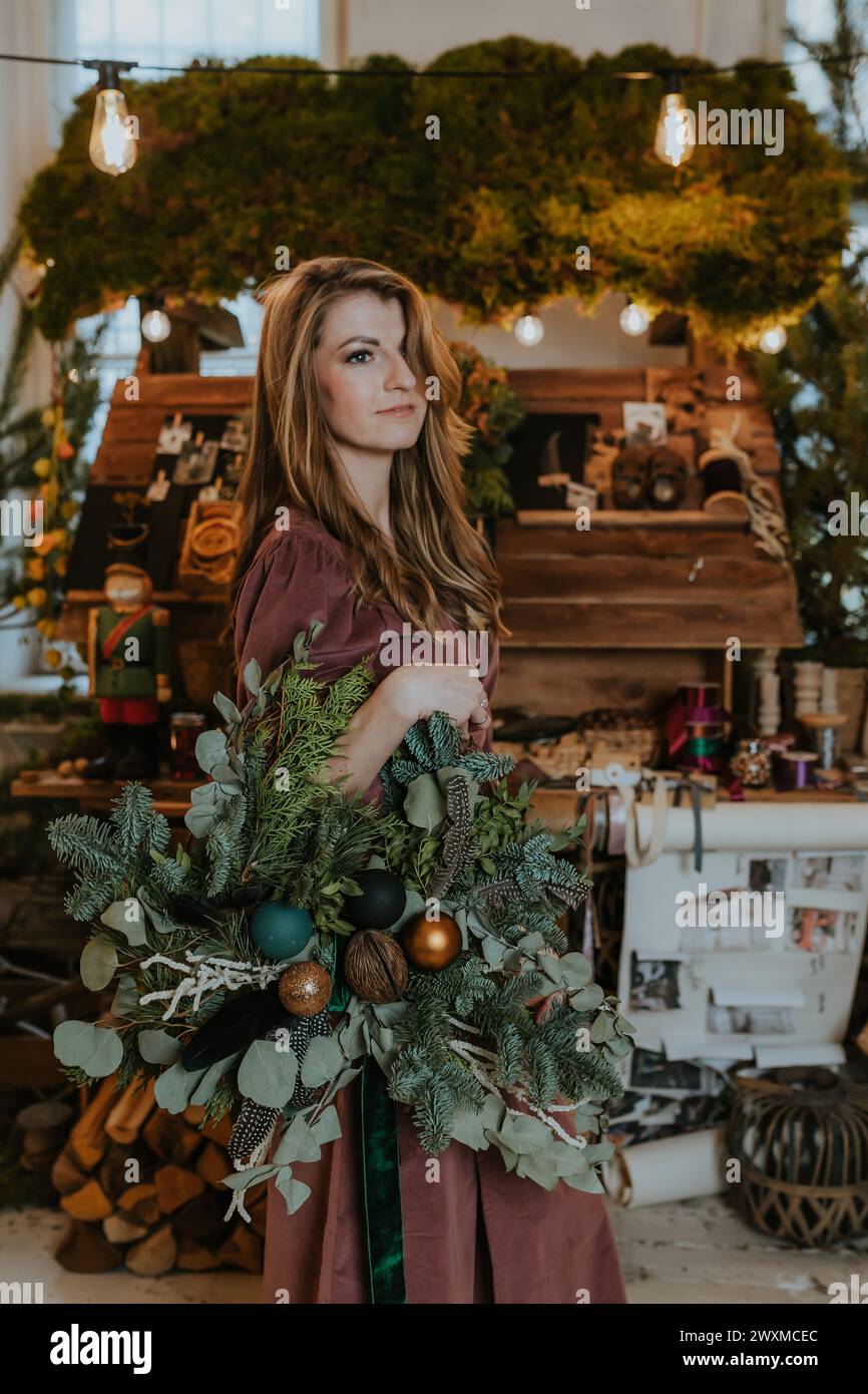 Donna che mantiene una ghirlanda di Natale Foto Stock