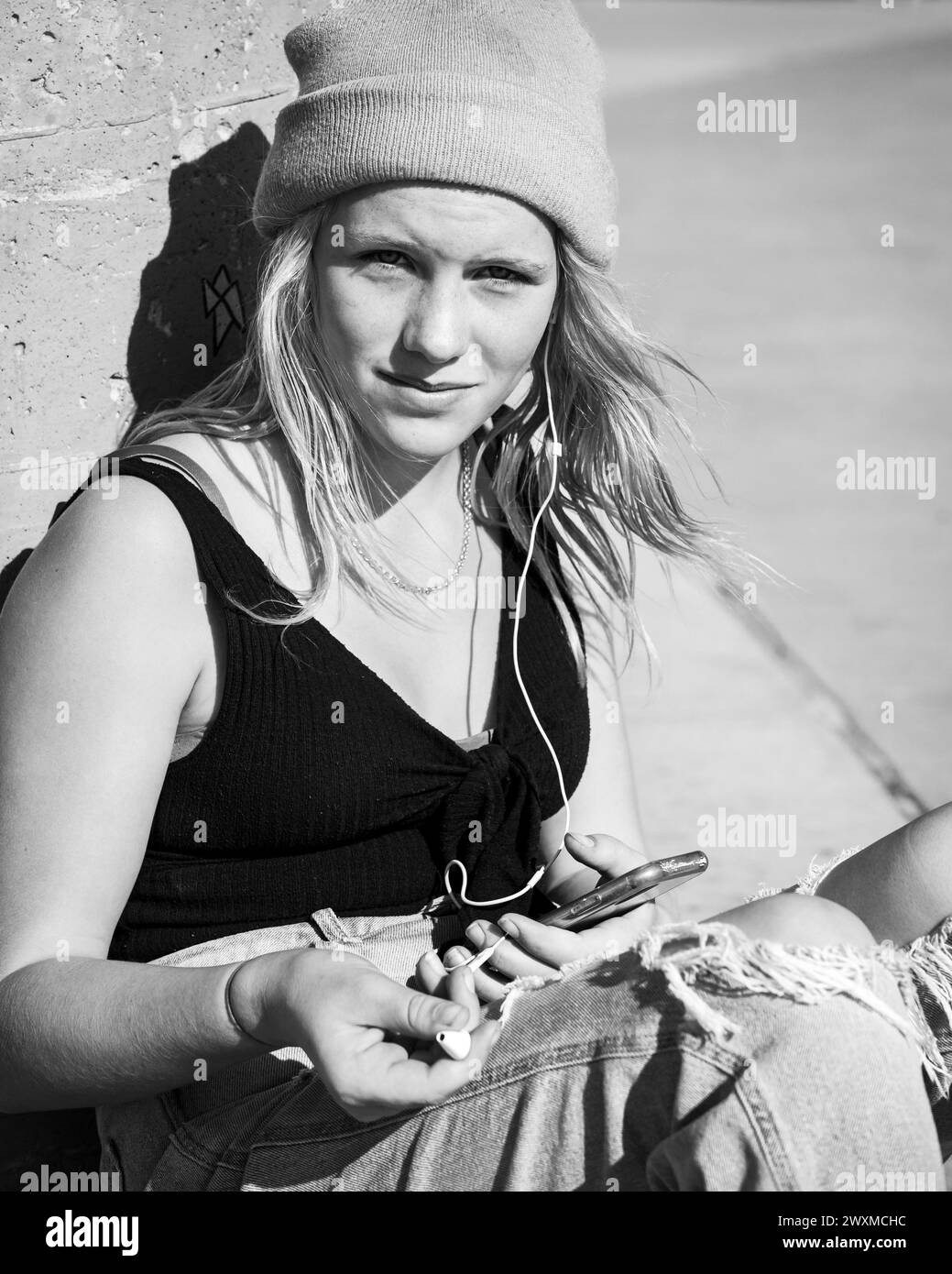 Skater girl che indossa berretto e cuffie Foto Stock