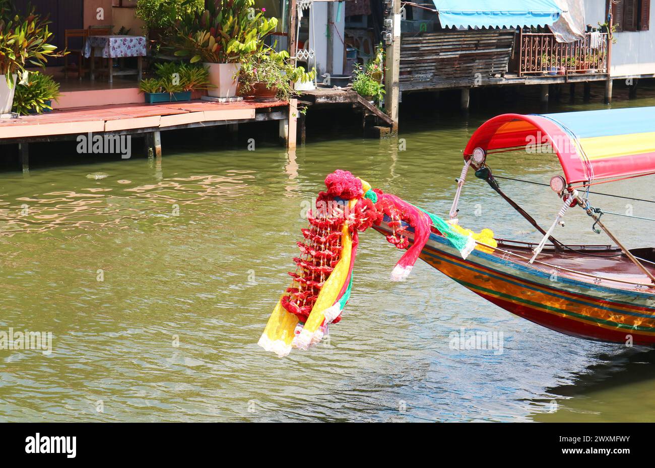 Ghirlande di fiori appese sulla prua tailandese della barca a coda lunga per l'offerta alla dea Mae Ya Nang Foto Stock