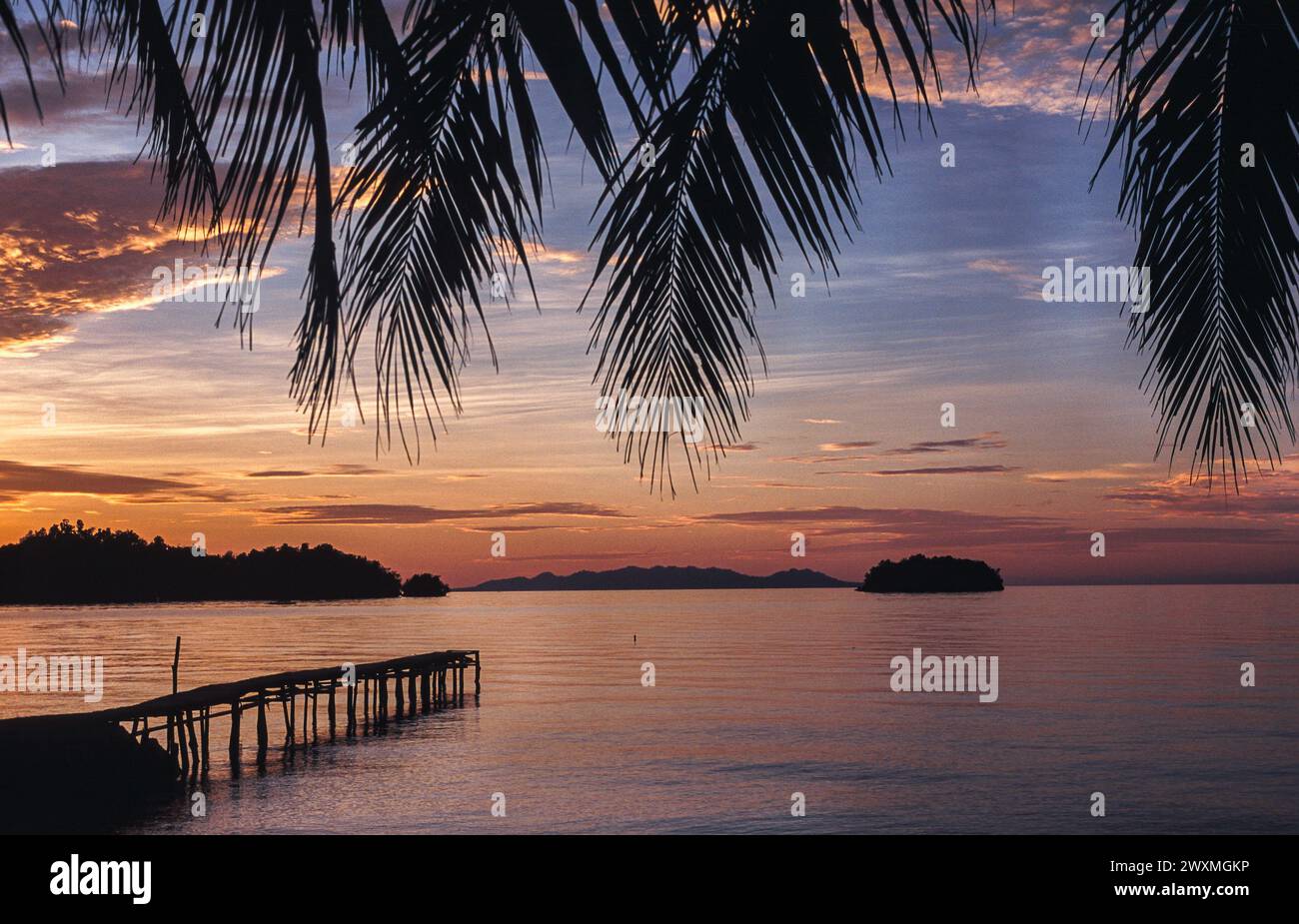 24.04.2009, Isole Togian, Sulawesi, Indonesia, Asia - tramonto panoramico su una paradisiaca spiaggia di palme in un'isola tropicale nel Golfo di Tomini. Foto Stock