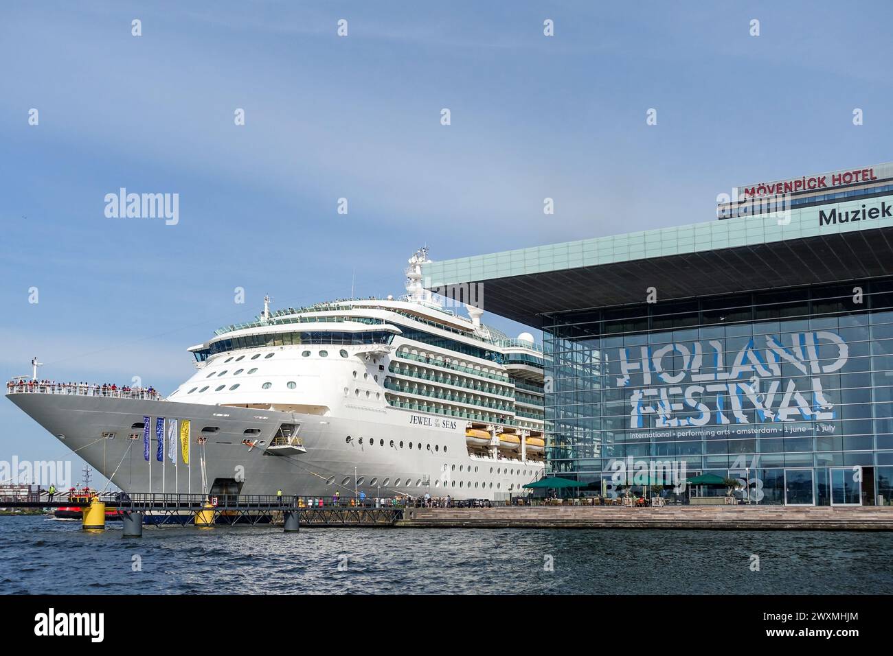 Grande nave da crociera bianca attraccata ad Amsterdam accanto alla moderna sala concerti di vetro Bimhuis durante l'Holland Festival Foto Stock