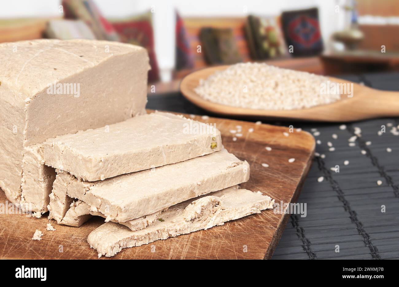 Tahini halva a fette, cucchiaio di legno con semi di sesamo da vicino Foto Stock