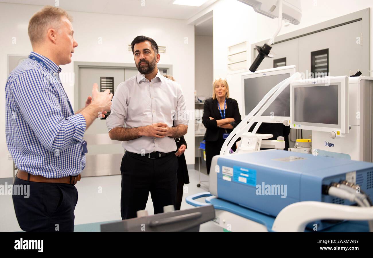 Primo ministro scozzese Humza Yousaf insieme al consulente chirurgo ortopedico Andy Ballantyne (a sinistra) durante una visita al Centro Nazionale di trattamento presso il Victoria Hospital di Kirkcaldy, Fife, per l'annuncio di un investimento per ridurre i tempi di attesa. Data foto: Lunedì 1 aprile 2024. Foto Stock
