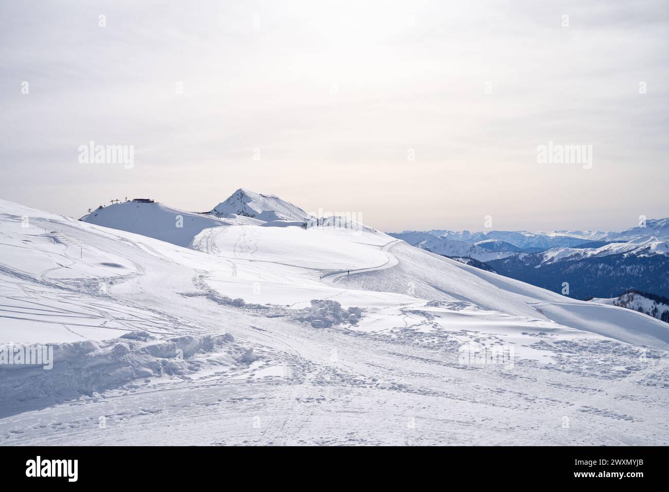 Una distesa tranquilla di cime innevate sotto un cielo morbido. Foto Stock